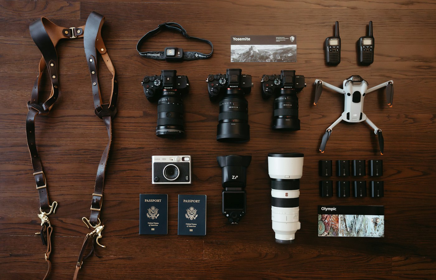 Photography kit laid out: camera bodies, lenses, flashes and a drone